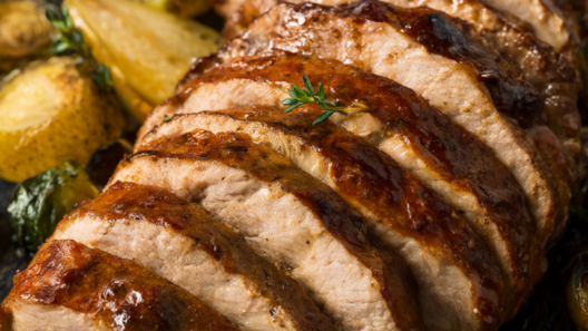 45-degree shot of honey balsamic pork tenderloin sliced into glossy glazed medallions, plated with caramelized pears and roasted Brussels sprouts, fresh thyme garnish on rustic dark wood.