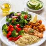 Balanced dinner plate with grilled salmon, quinoa, roasted vegetables and a spinach-tomato salad