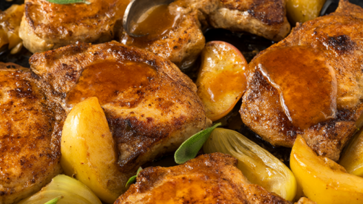 Golden-seared skillet pork chops with apples, onions and sage in a cast iron skillet