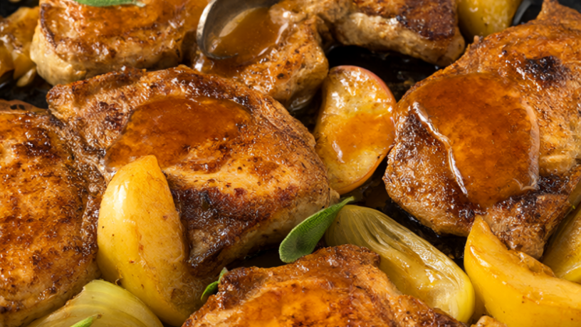 Golden-seared skillet pork chops with apples, onions and sage in a cast iron skillet