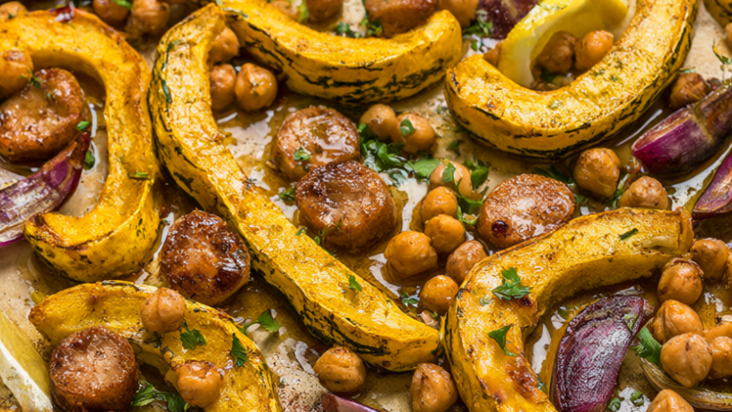 Sheet pan of roasted delicata squash half-moons with chicken sausage, chickpeas, and red onion