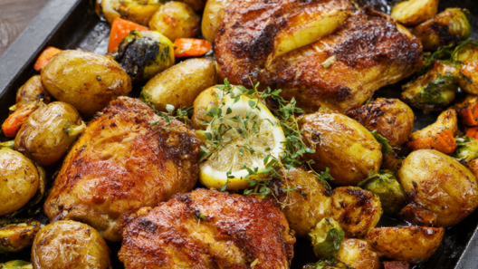 Roasted chicken thighs with baby potatoes, Brussels sprouts and carrots on a sheet pan