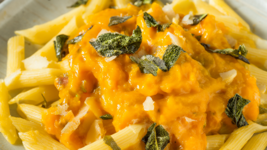 Penne pasta in creamy butternut squash sauce topped with crispy sage leaves and Parmesan