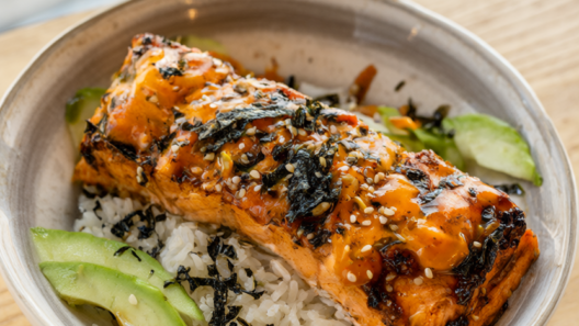 Spicy salmon rice bowl with flaky baked salmon, cucumber, avocado and sriracha mayo over jasmine rice