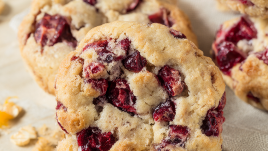 Cranberry orange cookies with fresh cranberries on a wooden bakery table