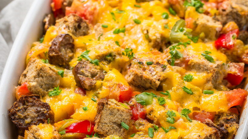 Golden-baked Christmas breakfast casserole with turkey sausage, sweet peppers and melted cheddar in a white baking dish