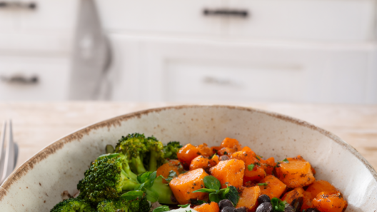 Healthy budget dinner bowl with brown rice, black beans, roasted carrots, broccoli and a soft-boiled egg