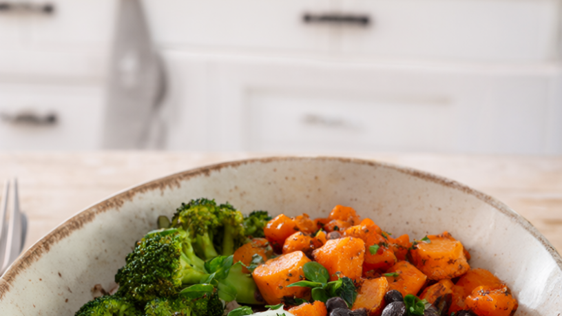 Healthy budget dinner bowl with brown rice, black beans, roasted carrots, broccoli and a soft-boiled egg