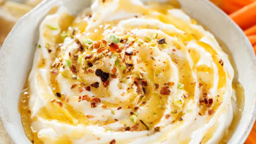 Whipped feta dip topped with chili honey, red pepper flakes and chopped pistachios, served with pita chips and carrots