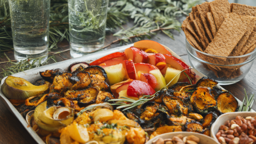 Holiday party table with roasted vegetables, fresh fruit, nuts, whole-grain crackers and sparkling water