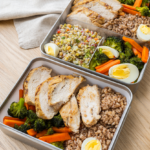 Three work lunch meal-prep containers with grilled chicken, brown rice and roasted vegetables