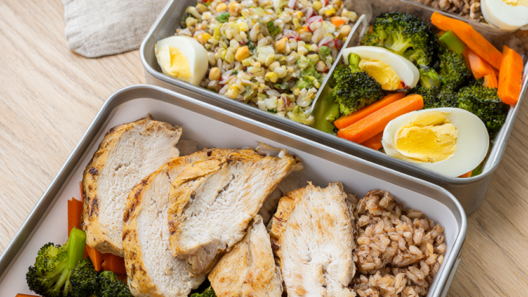 Three work lunch meal-prep containers with grilled chicken, brown rice and roasted vegetables