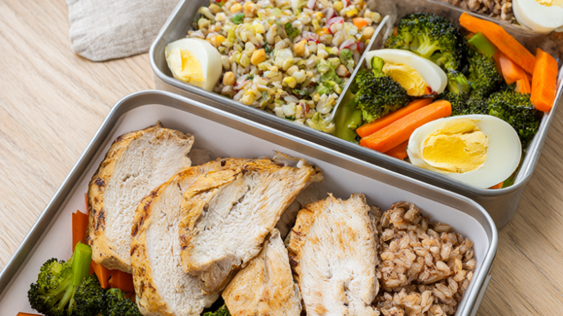 Three work lunch meal-prep containers with grilled chicken, brown rice and roasted vegetables